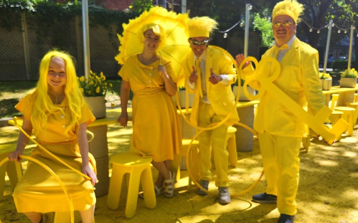 Quatre personnages tout en jaune lors d’une animation en plein air